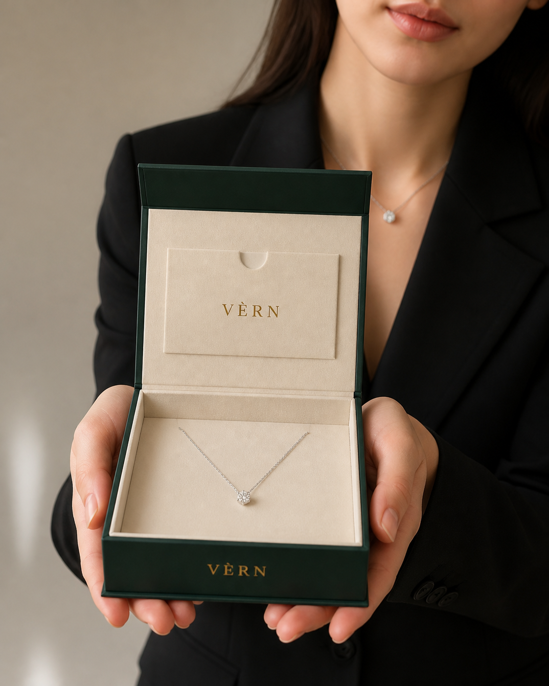 실제 VÈRN 케이스 안에 라운드 팬던트가 놓여 두 손 사이로 건네지는 모습